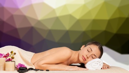 Obraz na płótnie Canvas Beautiful young woman receiving hot stone massage at salon spa