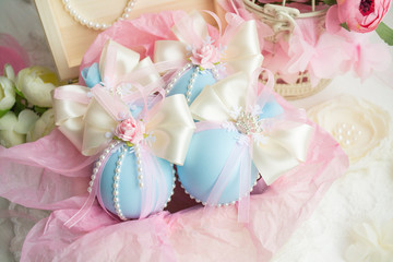 winter vacation. New Year's toys made by hand. a set of Christmas balls of blue color with a bow of satin ribbon, lace, flowers lies in a box with pink paper.