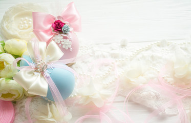 Fototapeta na wymiar winter vacation. New Year's toys made by hand. Christmas balls of pink, blue color with a bow of satin ribbon, lace, pearls, flowers lies on a white wooden background