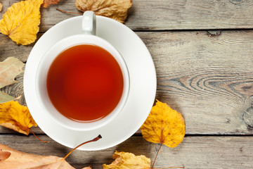 Cup of tea and autumn leaves on the table