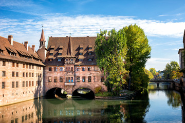 Fototapeta na wymiar Nuremberg, Heilig-Geist-Spital which is reflected in the waters of the Pegnitz river. Franconia, Germany