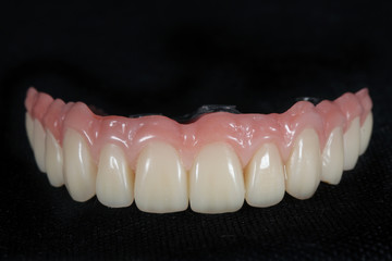 Made ceramicite prosthesis with titanium beam, front view on black background