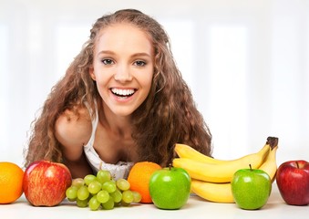 Attractive young woman enjoying fruits on breakfast