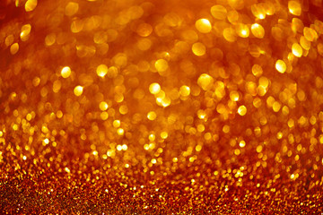 Red and gold abstract bokeh lights. Shiny glitter background with copy space. New year and Christmas concept. Sparkling greeting card