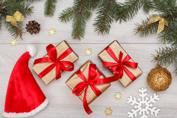 Santa's hat, gift boxes, fir tree branches with cones and christmas toys