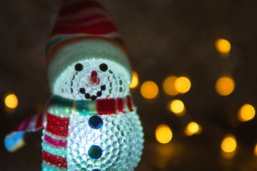 Christmas toy glowing snowman in the dark with copy space