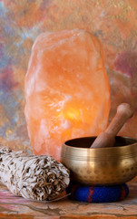 Singing bowl, white sage smudge stick and Himalayan salt lamp.