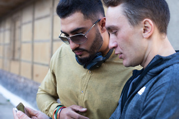 two friends watching a video on cellphone