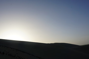 Desert sand dunes with blue sky background