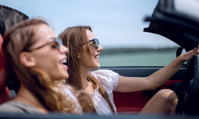Two attractive young women in a cabriolet car