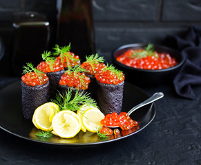 Pancakes with cuttlefish ink with red caviar. Russian kitchen.