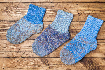 Fototapeta na wymiar Warm wool knitted socks for cold winter on wooden background.