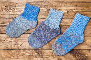 Warm wool knitted socks for cold winter on wooden background.
