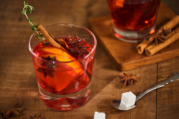 Cold ginger tea with orange and lemon in glass cups. Tea with sugar. The decor. Cinnamon and Rosemary Spices