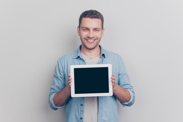 Photo of good-looking nice man show pc gadget on camera stand is