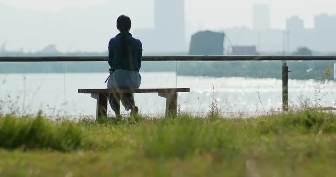 Woman enjoy the seaside and sitting on the bench