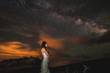 Bride posing under the Milky Way stars in the Utah desert.