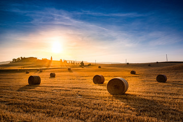 Sunrise Over Farm Field With Hay Bales