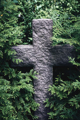 old stone cross in branches