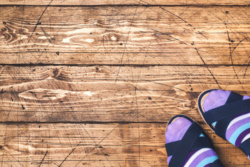 Women's feet in socks and sandals on wooden background. Copy space