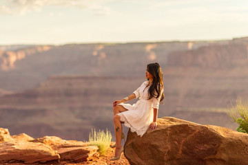 Asian/Vietnamese Bride posing for a Sunset engagement photo on the cliffs of the scenic Dead Horse Point State Park.  A massive overlook of the vast canyons of the Utah desert