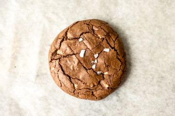 Naklejka premium Chocolate chip cookie with pinch of salt, flat lat photo
