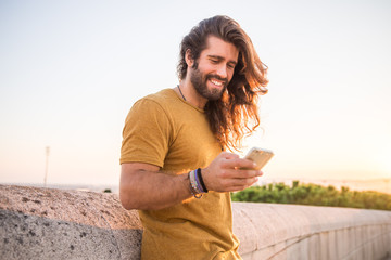 young man with long hair using his mobile phone