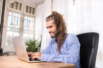 hair wearing a blue shirt working with his laptop in a office