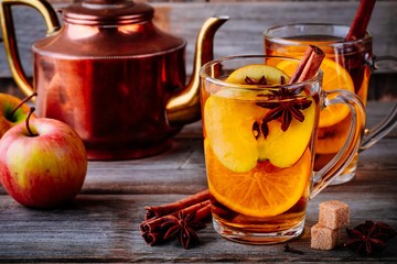 Hot mulled apple cider drink with cinnamon stick, cloves and anise