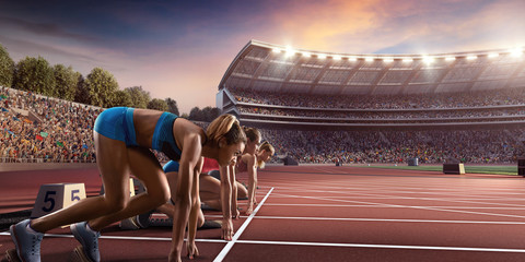 Female athletes sprinting. Three women in sport clothes on starting line prepares to run at the running track in professional stadium - obrazy, fototapety, plakaty