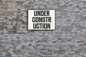 Fototapeta na wymiar Under Construction in light box on brick wall
