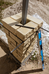 The worker is laying bricks on the fence