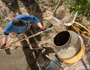 Workers pour concrete solution at a construction site