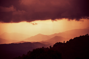 Overlapping mountains with cloudy and rain