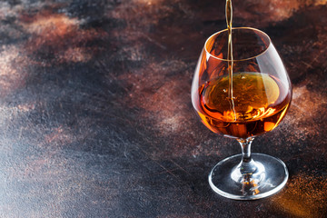 Cognac Pour Into Glass, Vintage Brown Background, Selective Focus