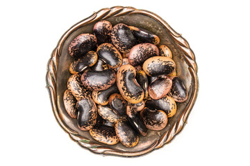 Lot of whole speckled colored butter beans painted lady scarlet runner variety in old iron bowl flatlay isolated on white background