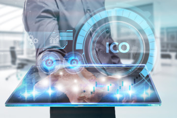 The concept of business, technology, the Internet and the network. A young entrepreneur working on a virtual screen of the future and sees the inscription: ICO