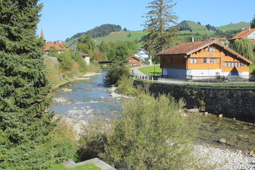 Fototapeta na wymiar Landscape. Bend of mountain river and typical rural houses on clear summer sunny day..