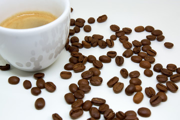 A cup of coffee on the background of coffee beans