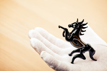black horse figure hand white gloves table 