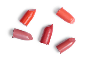 top view of cut lipsticks on different colors on white backdrop