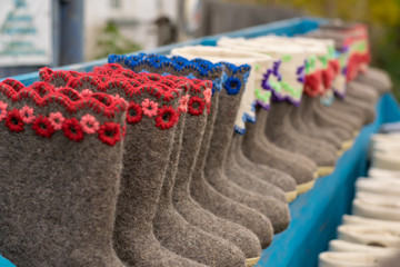 Various Slippers, shoes, boots made of sheep wool are on sale at the village counter