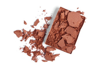 top view of cracked brown eyeshadow on white backdrop