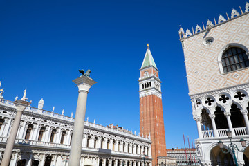 Fototapeta na wymiar San Marco bell tower and lion staue on column, National Marciana library and Doge palace wide angle view, clear blue sky in Venice, Italy