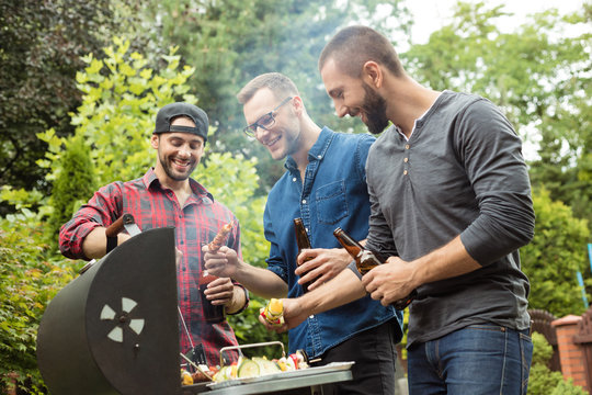 Three young men enjoying barbecue party