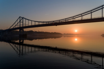 Fototapeta na wymiar Sunrise aerial view of pedestrian Park bridge and Dnipro river in Kyiv, Ukraine