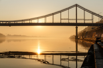 Sunrise view of pedestrian Park bridge and Dnipro river in Kyiv, Ukraine