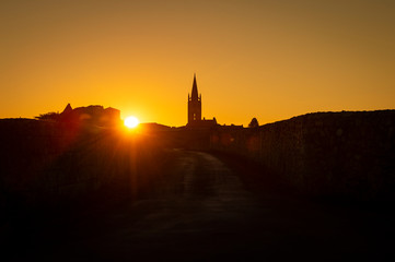 Beautiful sunrise on the steeple of the church and village of Saint Emilion, Religion, Gironde