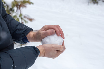 man sculpts snowball