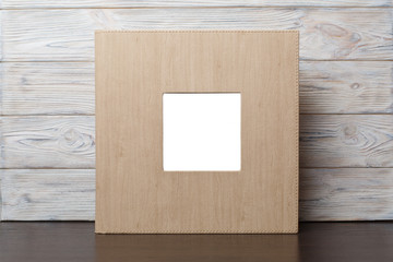 photo book with  leather cover.
Wedding photo album.
Beige photobook on a wooden background.
photo album with insert


